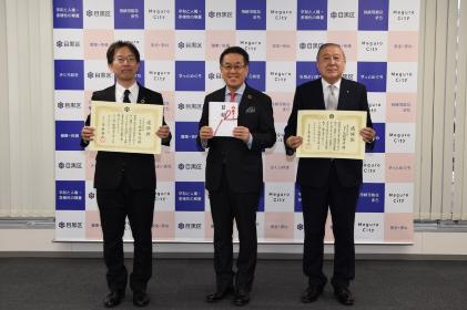 感謝状を手に目黒区長と記念撮影をする様子