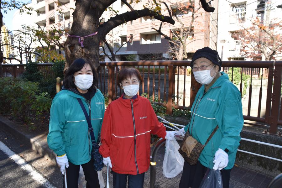 ごみを拾う3人のボランティア