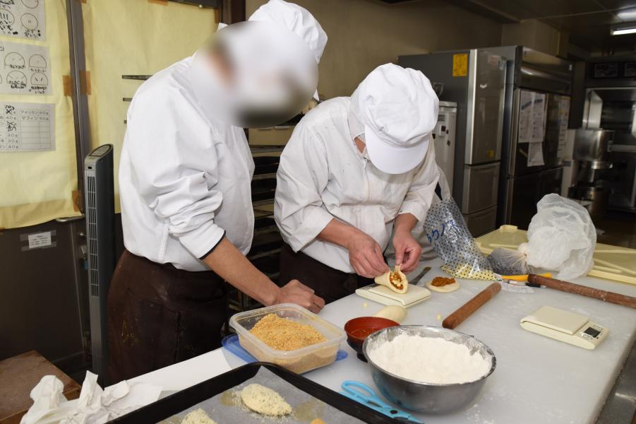 支援員とパンを包む写真