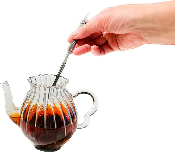 スプーンでポット内の紅茶をひと混ぜしている画像