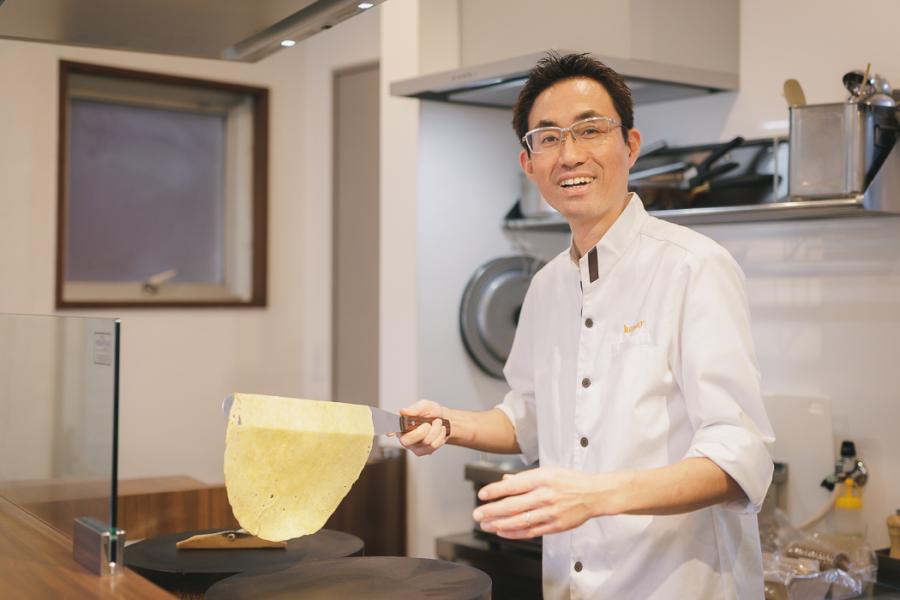 クレープ生地を持ち上げる込山さんの写真