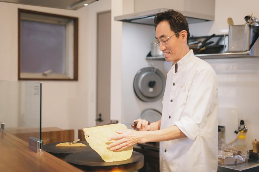 クレープ生地をひっくり返す込山さんの写真