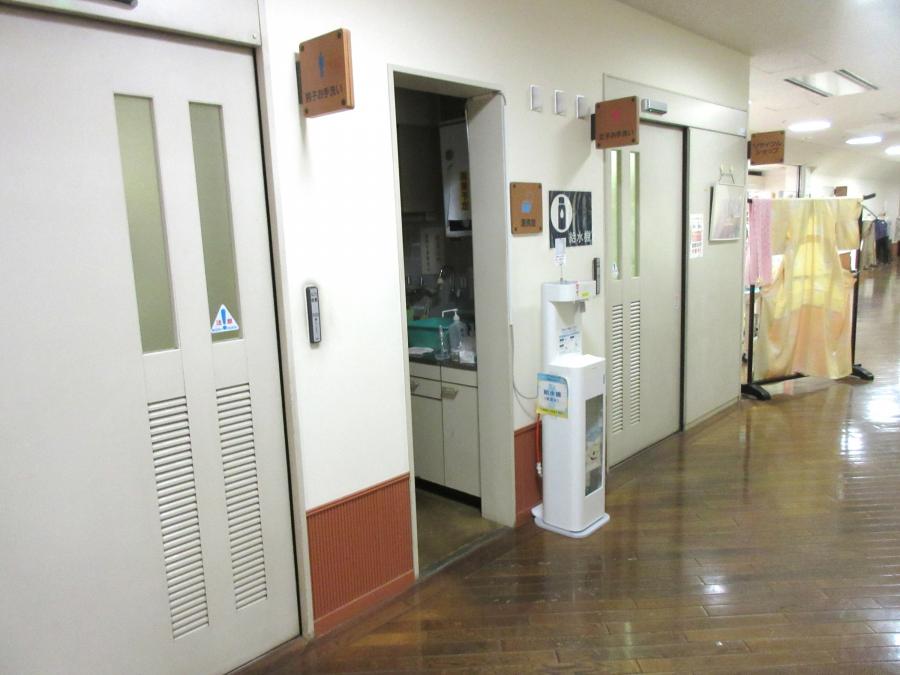 エレベーターを降りて左へ進みすぐ左に曲がります。進むと男子トイレがありその先に給湯室があります。給水機は給湯室入口の横にあります