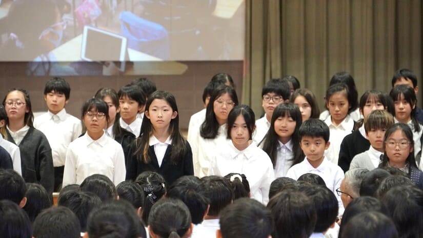 発表する6年生の真剣な表情をアップした写真。