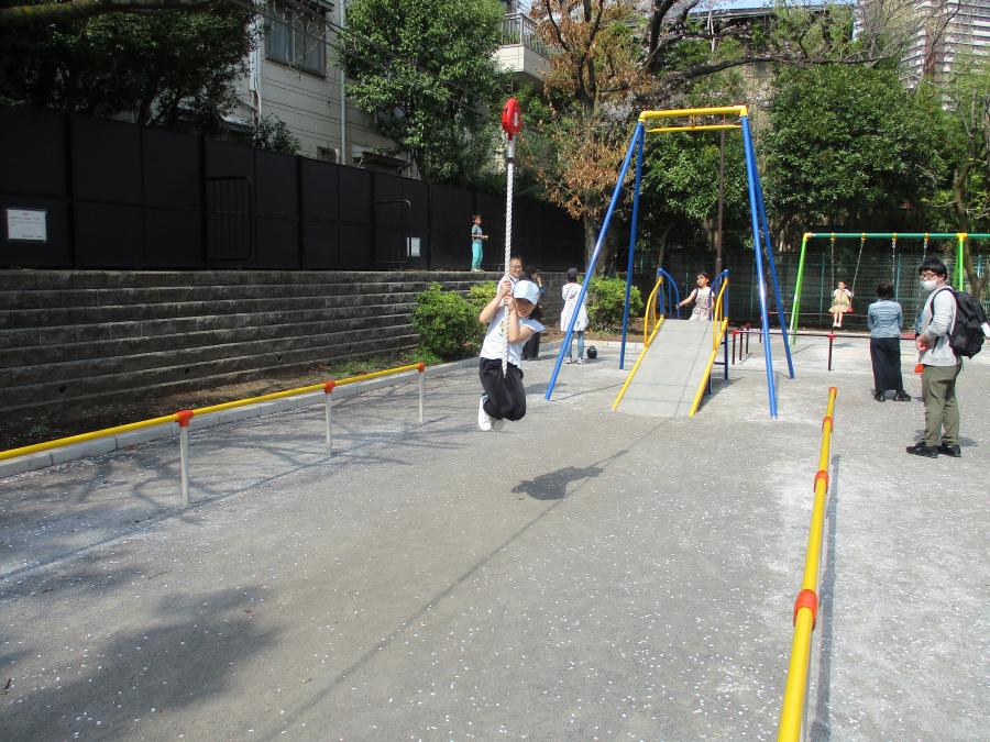 三田公園のターザンロープにぶら下がって遊ぶ子どもの写真