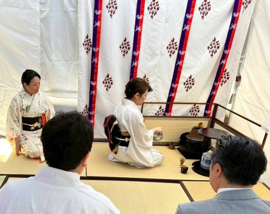 和装をした女性がお茶を点てている様子